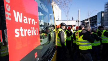 Demonstrierende Busfahrer in Reutlingen, Baden-Württemberg, neben einem Linienbus