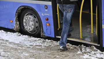 Frau, die in einen Linienbus der MVG in München einsteigt