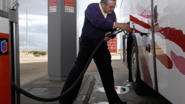 Busfahrer, der einen Reisebus betankt (in Spanien)