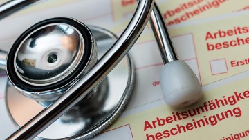 Arbeitsunfähigkeitsbescheinigungen mit Stethoskop 