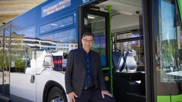 Intendant der Staatsoper Hannover Bodo Busse vor einem Linienbus, der Gäste zukünftig zur Oper bringt