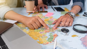 Reiseplanung zweier Menschen mit Landkarte