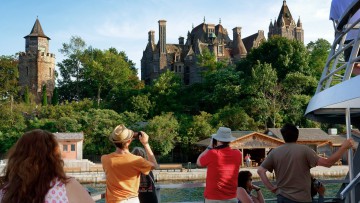 Touristen auf einem Schiff, die ein Schloss fotografieren