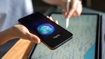 Reiseplanung mit KI: Frau mit Smartphone und Tablet, die KI nutzt