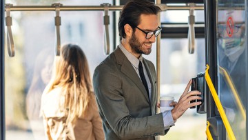 Mann mit E-Ticket auf Smartphone im Bus