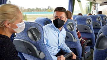 Busreisegäste mit Maske, Gruppenreise mit Bus