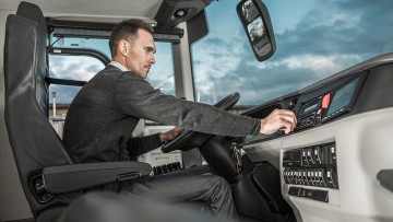 Reisebusfahrer am Steuer eines Reisebusses, der seine Fahrt vorbereitet