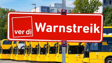 Gelbe Doppeldeckerbusse in Berlin mit einem Schild, auf dem "Streik" steht