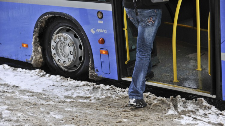 Frau, die in einen Linienbus der MVG in München einsteigt