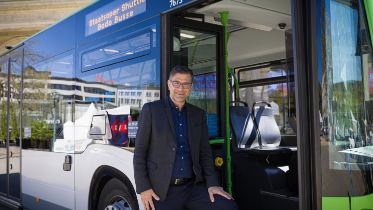 Intendant der Staatsoper Hannover Bodo Busse vor einem Linienbus, der Gäste zukünftig zur Oper bringt