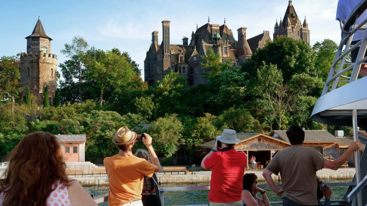Touristen auf einem Schiff, die ein Schloss fotografieren