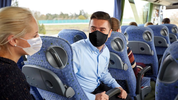 Busreisegäste mit Maske, Gruppenreise mit Bus
